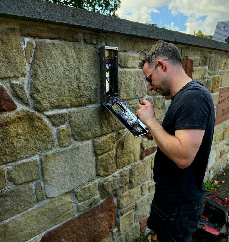 automatic gate engineer fixing a gate control panel