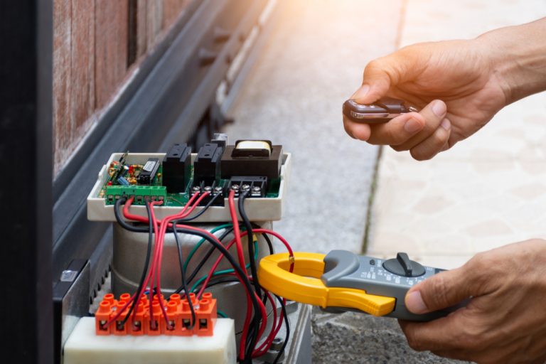 Technician repairing and testing sliding gate